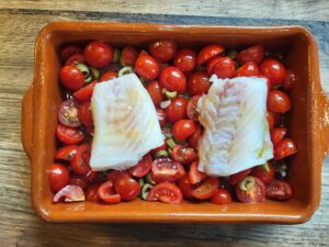 Kabeljau auf Tomaten vor dem Backen im Ofen